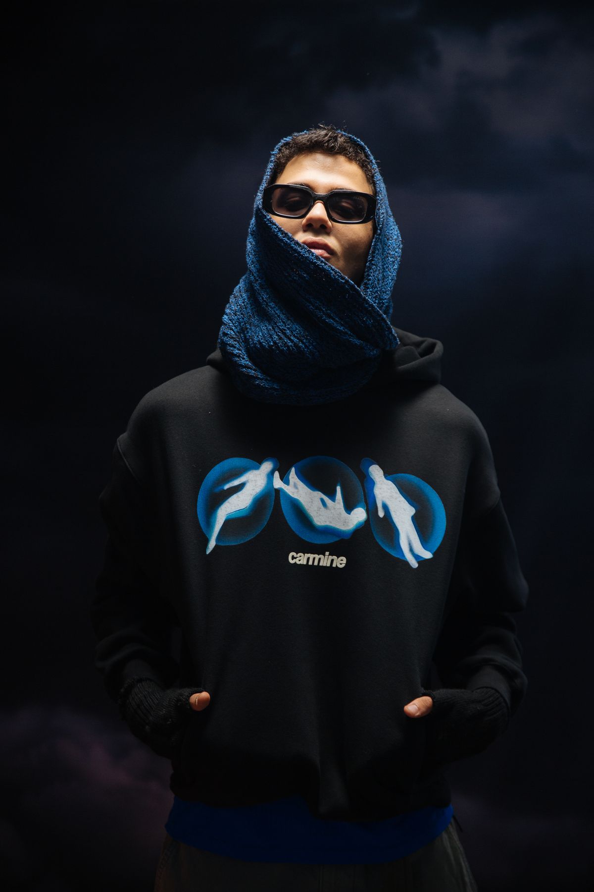 Model in a blue balaclava and black hoodie