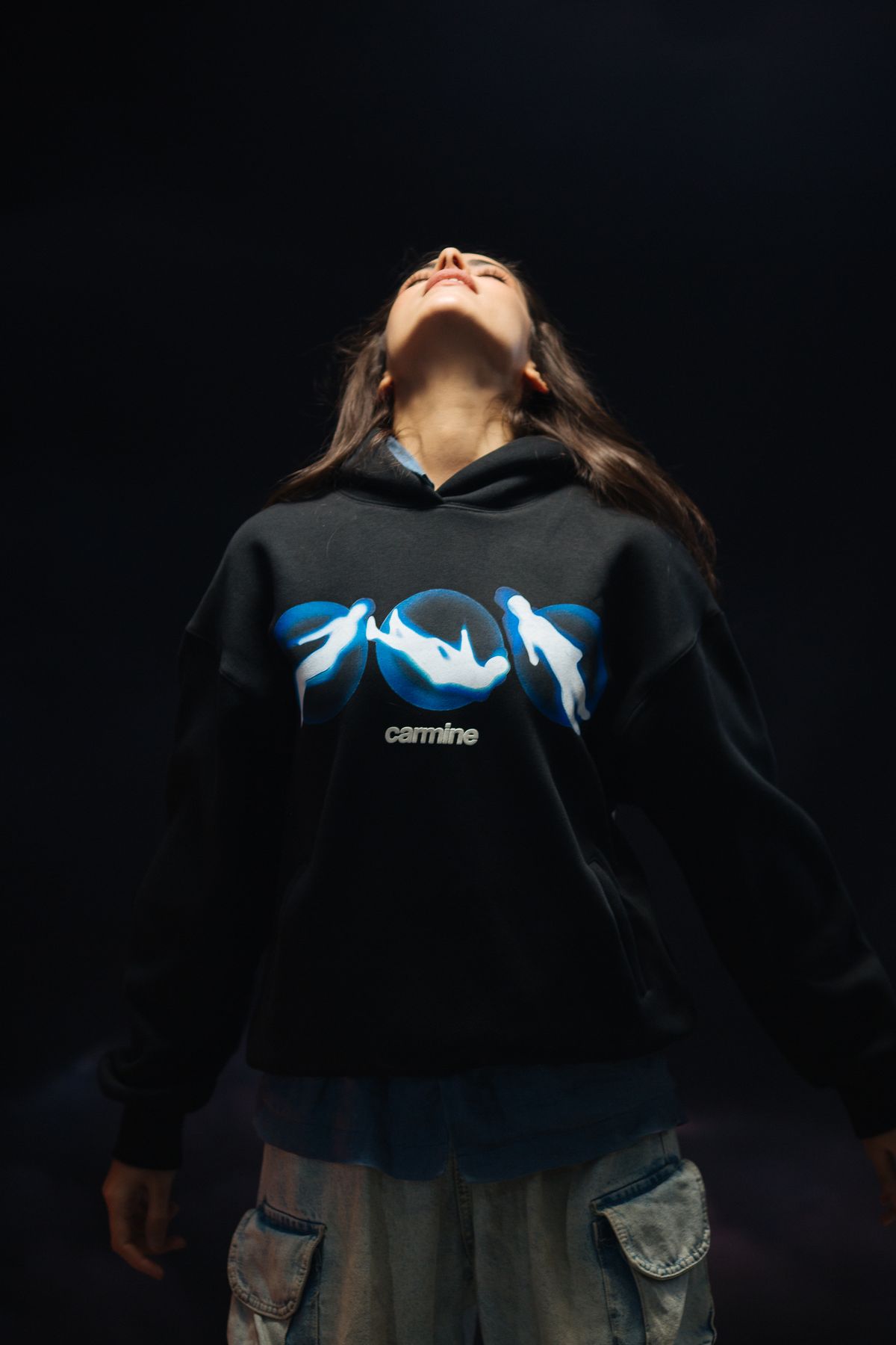 Model looking up in a black graphic hoodie