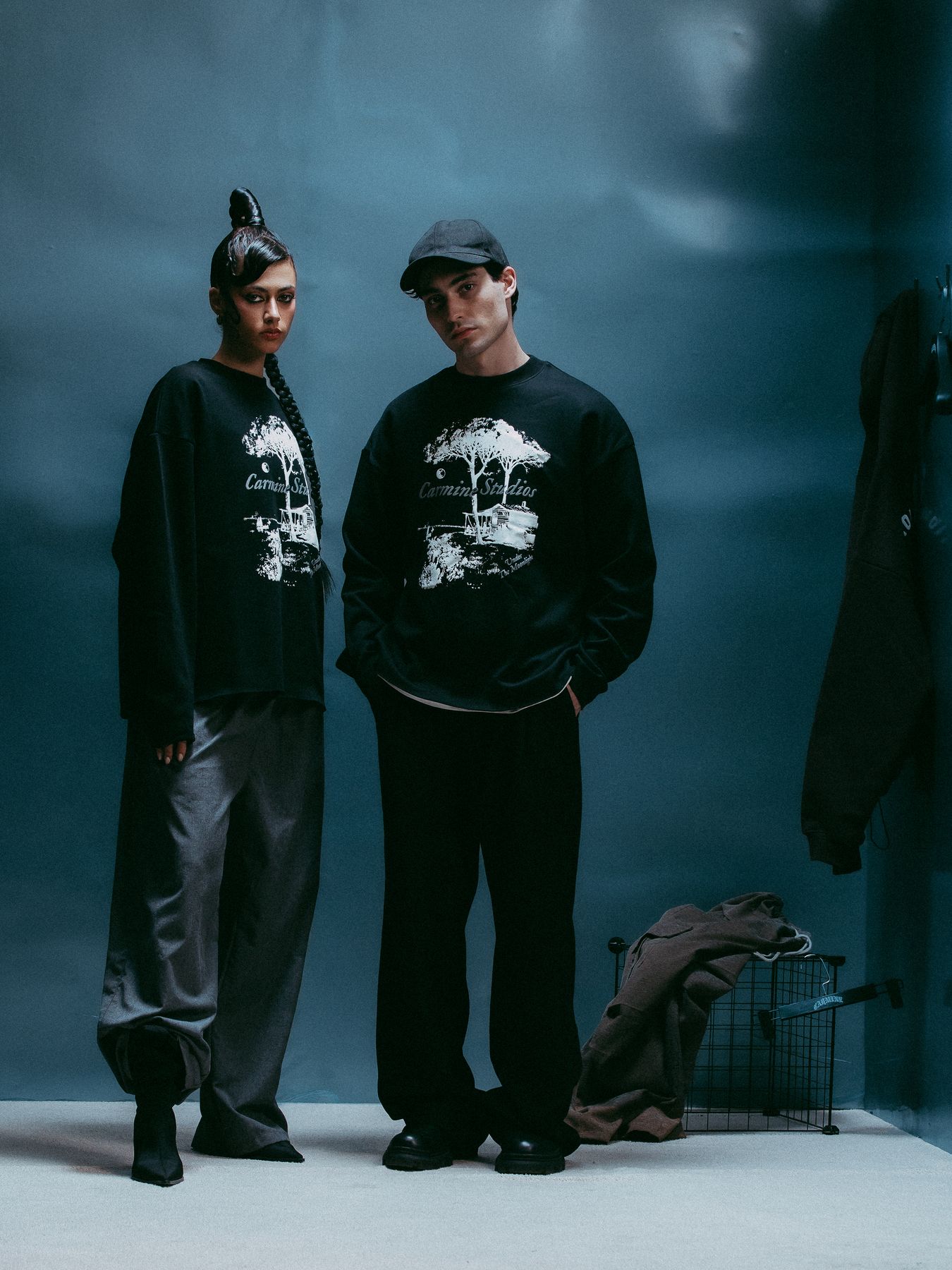 Two models standing by the coat rack