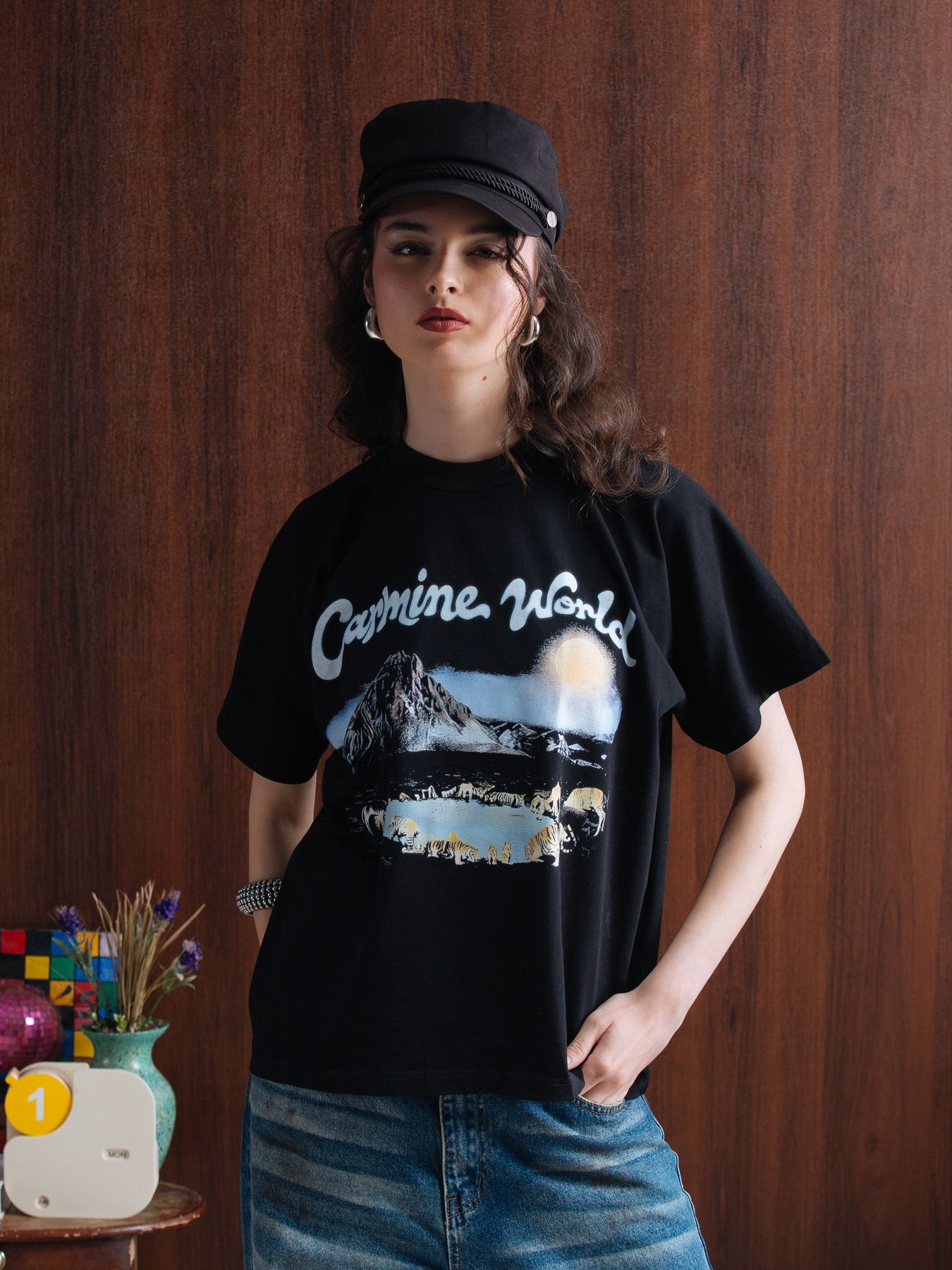 Model in a black Carmine tee and cap